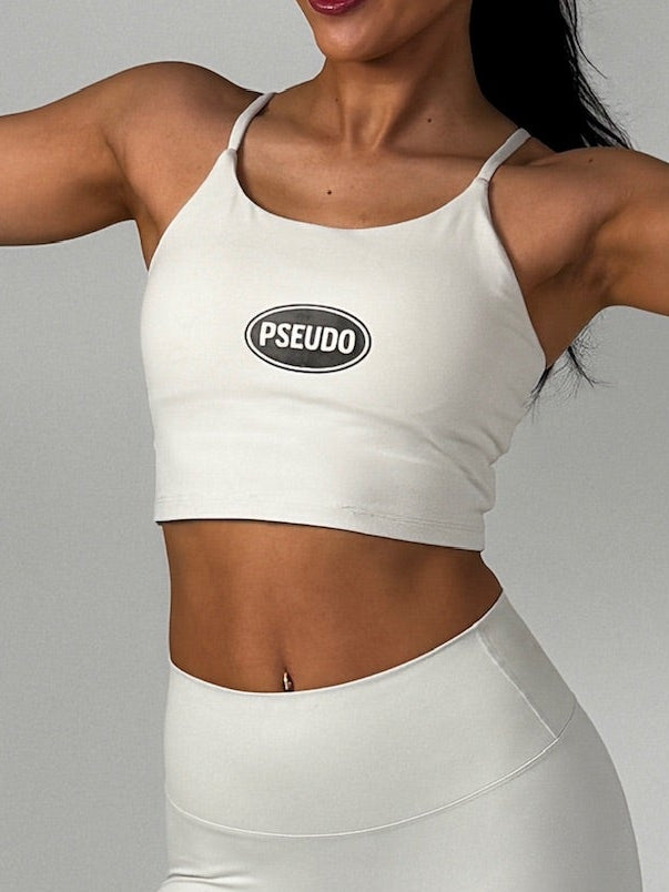 Woman in white athletic wear with 'PSEUDO' logo lifting weights against a gray background